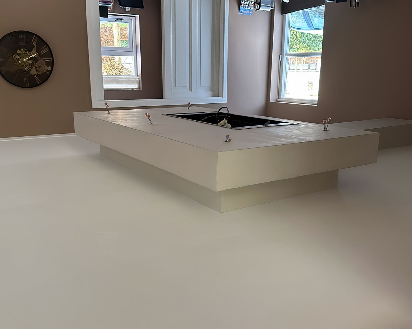 Gestuct keukenblok met inbouwkookplaat in een ruimte met taupe wanden
